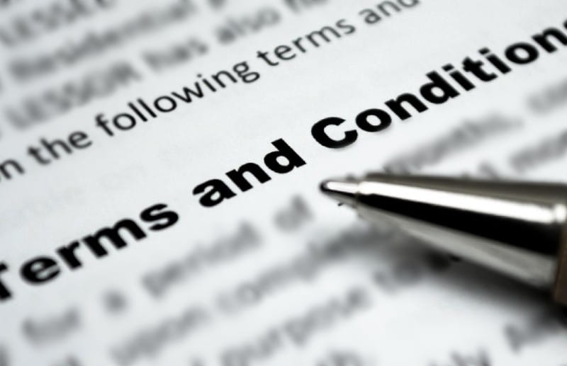 Blurred text with a pen nib in the right bottom corner, text diagonally from bottom left to top right ' Terms and Conditions'