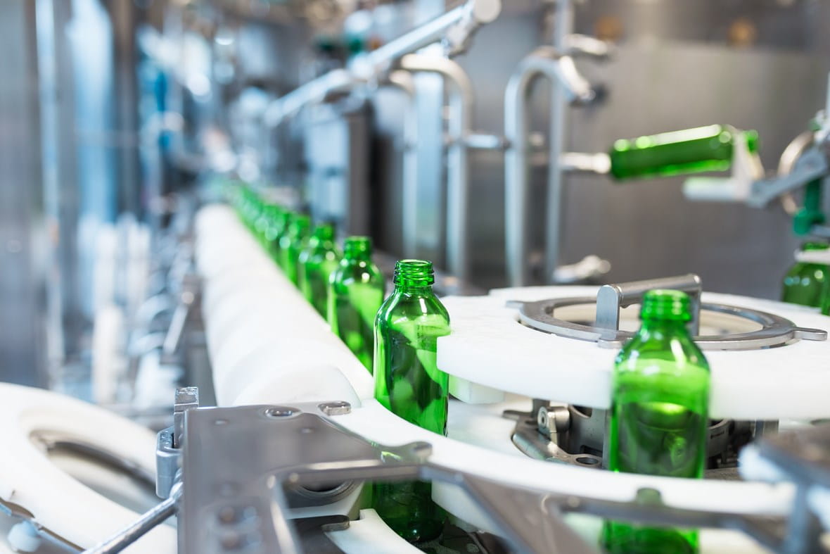 Green glass bottles on bottle inspection and filling machine line