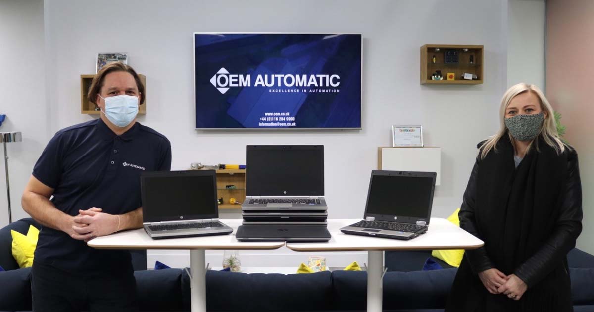 OEM Automatic's Operations Manager Adam Parkin and Countesthorpe Academy's Mrs McKenzie, OEM donating laptops