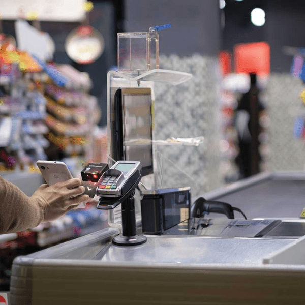 Retail checkout till with card machine, code reader and till screen, demonstrating barcode scanner use in retail